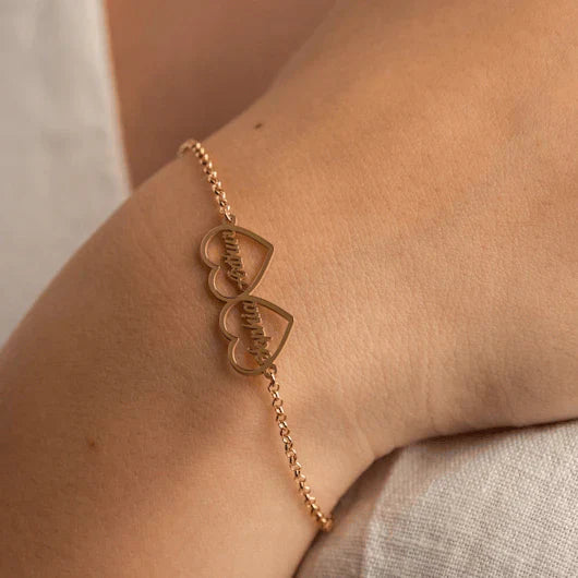 Model's wrist adorned with an Eraya Jewel Golden 'His and Hers' Heart Name Bracelet, emphasizing the custom name and elegant heart detail.