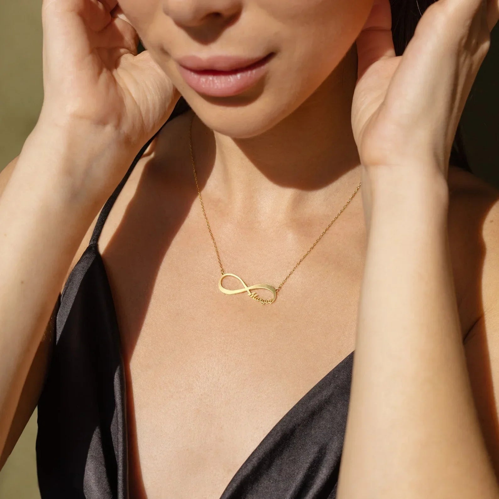 Model wearing the Personalized Name Infinity Necklace, available in both gold and silver, celebrating love and endless connection