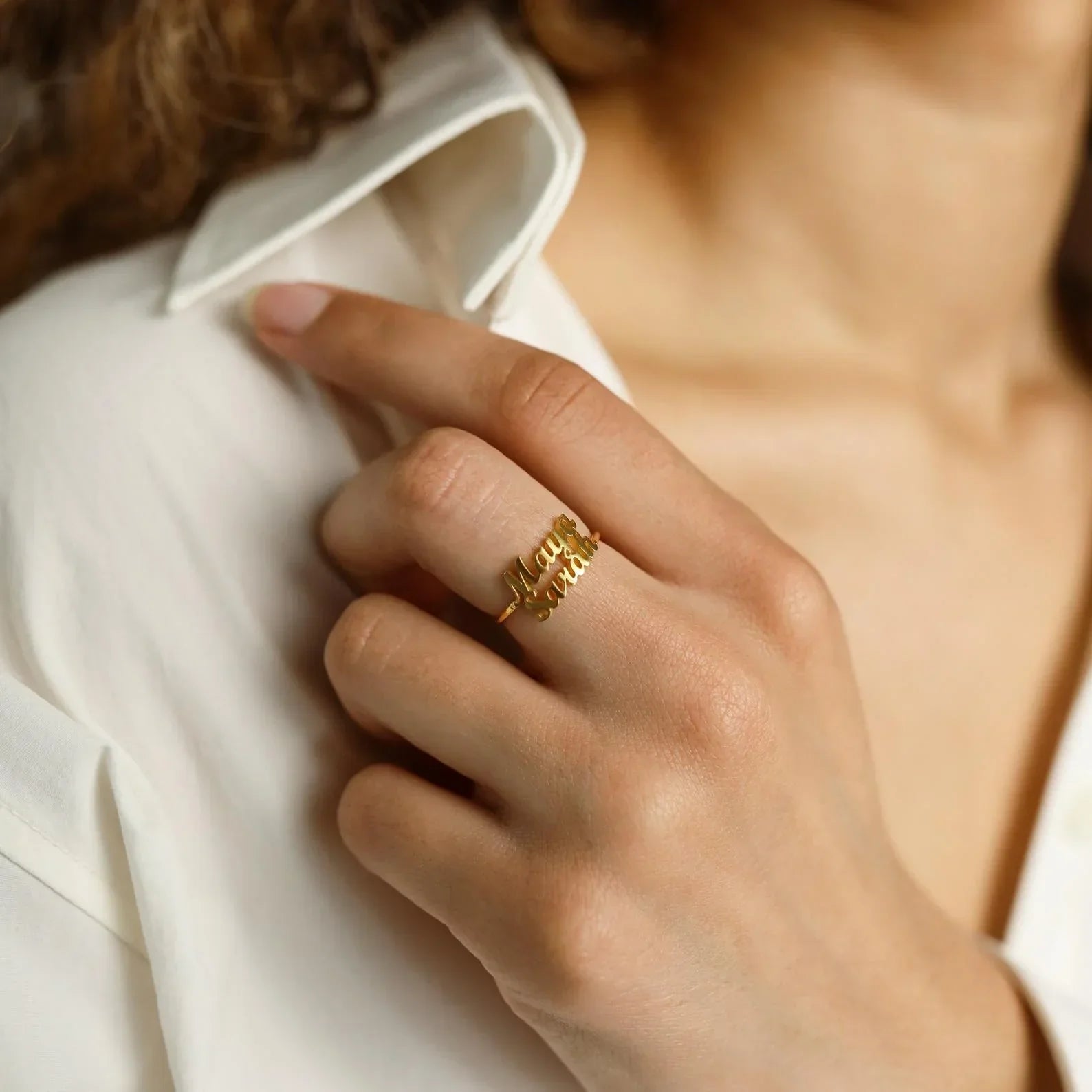 A lifestyle shot of a couple wearing the "Custom His and Hers London Name Rings," demonstrating how the rings look when worn and their symbolic connection.