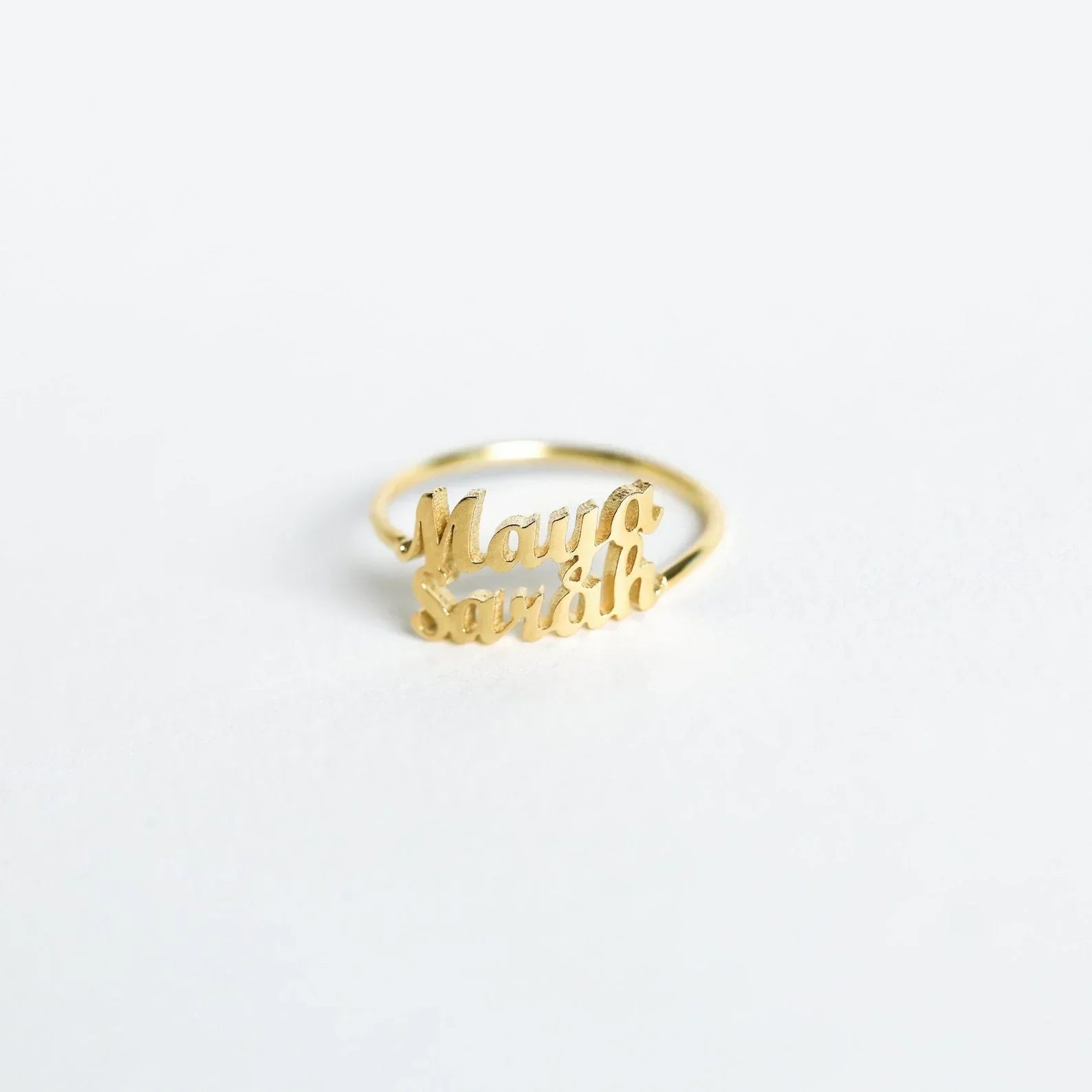 a London-inspired rings, one slightly larger than the other, each engraved with a different name, emphasizing the personalized nature of the set.