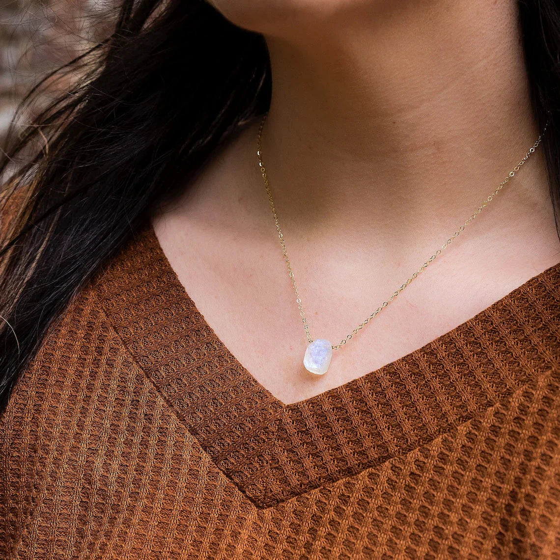Natural Rainbow Moonstone Necklace featuring an oval-shaped moonstone pendant with a sterling silver setting, displayed against a white background.