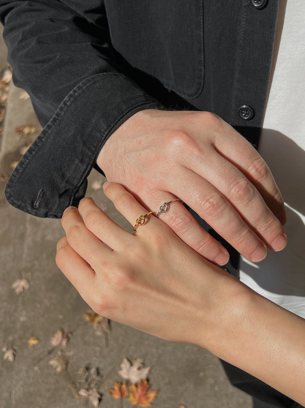 Modern gold and silver couple rings with knot design, symbolizing love and unity.
