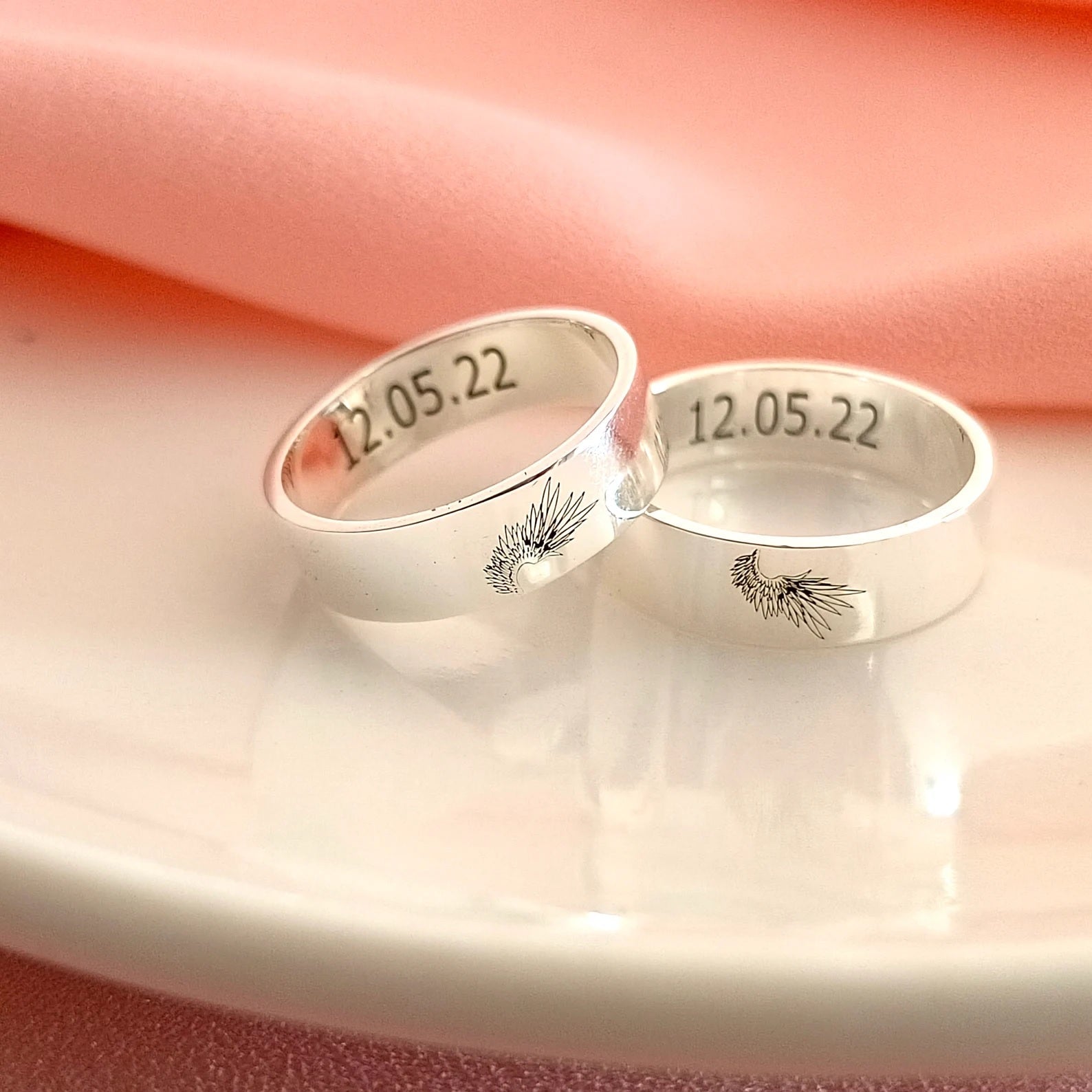 Matching set of silver Angel Wing Couple Rings displayed together, symbolizing love and protection.