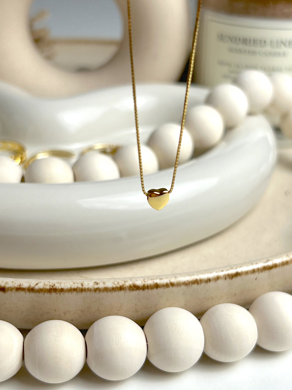Close-up of a minimal gold heart necklace with fine detailing, perfect for romantic everyday wear.