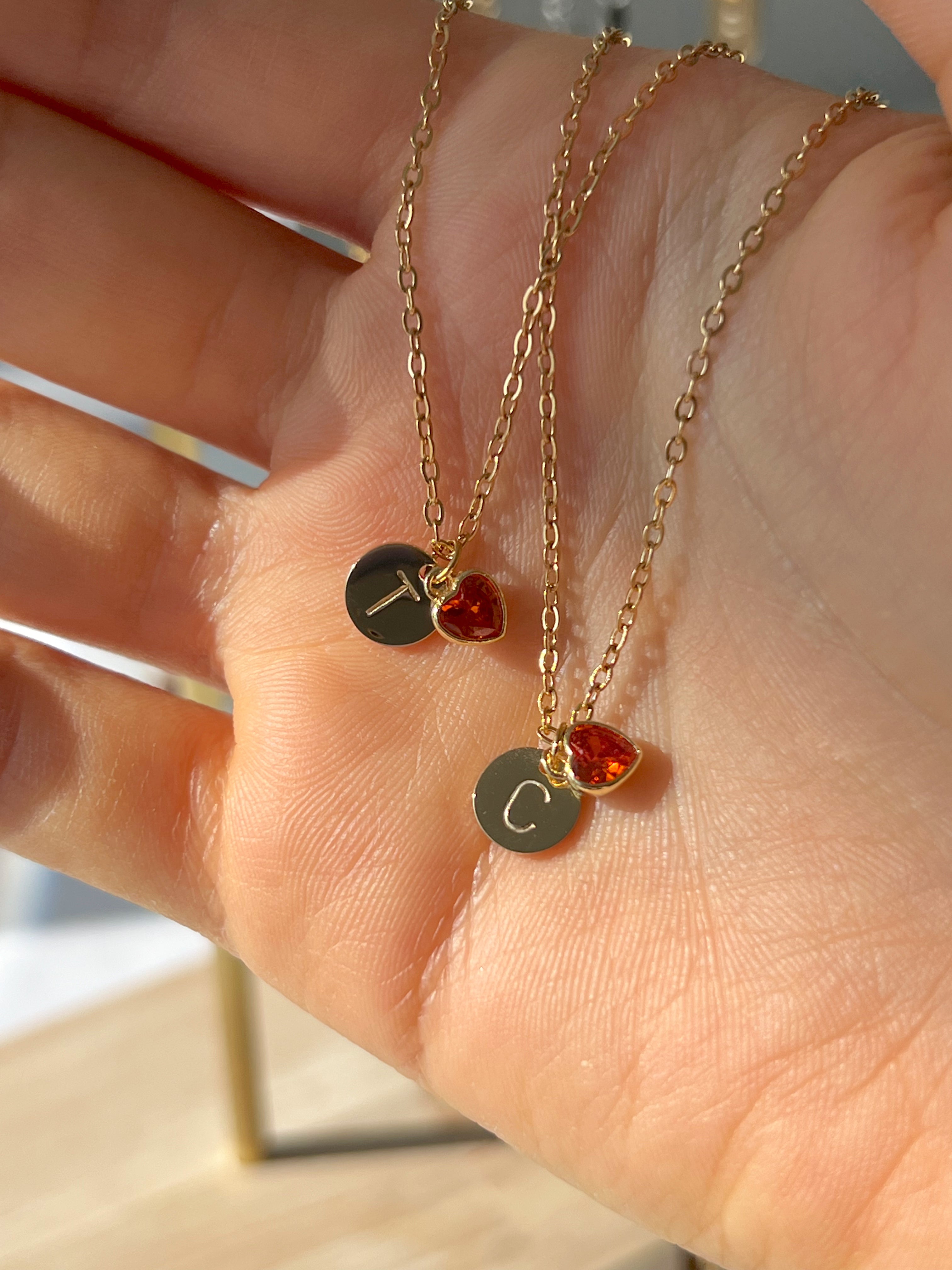 Gold polished initial pendants in hand hidden engraving, styled for a minimal everyday look