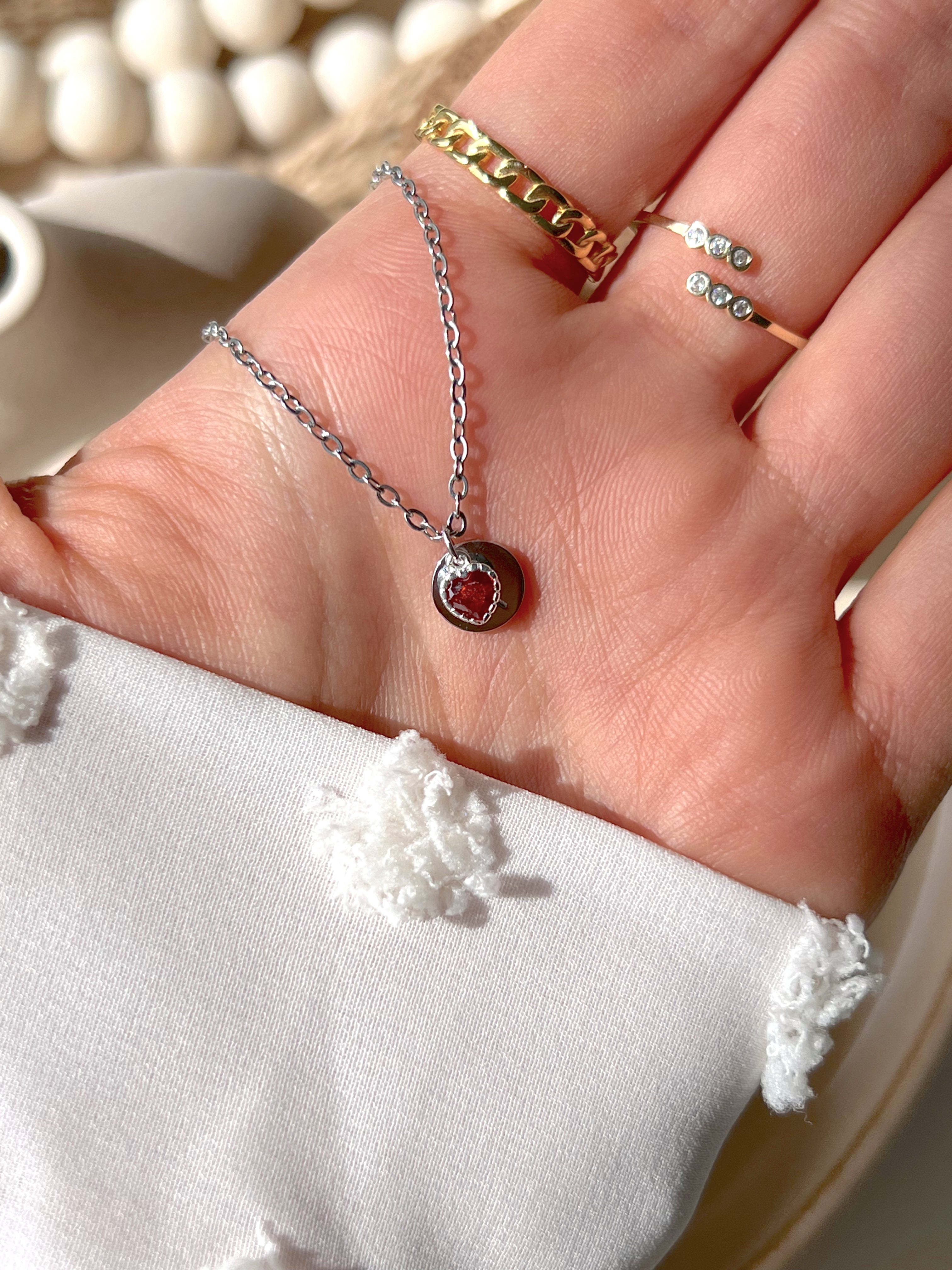 Model hand showing silver secret initial pendant 